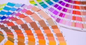 Abanico de muestras y cartas de color que ilustra el simbolismo y usos del color berenjena en diseno junto a combinaciones cromáticas