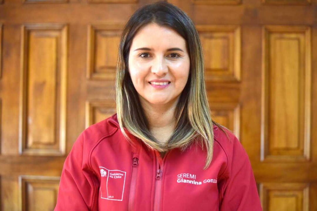 Mujer sonriente con chaqueta institucional y fondo de puerta de madera, tasacion mas alta que el precio de compra en chile descubre que hacer