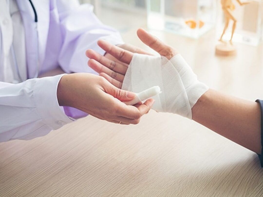 Profesional de la salud vendando la mano de un paciente tras una quemadura, te quemaste con agua hirviendo descubre que hacer en segundos 1
