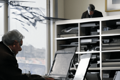 Personas en una oficina revisando papeles y ordenador mientras consideran tengo la itv caducada y no hay cita que debo hacer.