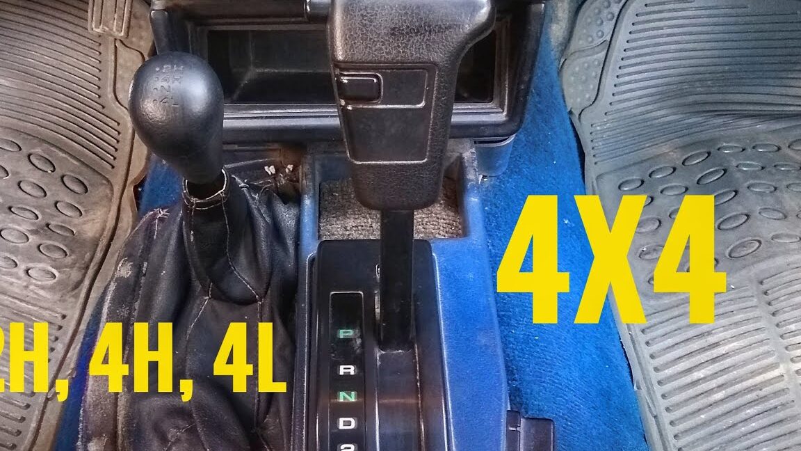 Interior de vehículo con palancas de cambio y transferencia 4x4 mostrando texto amarillo y todo lo que necesitas saber sobre el significado de 2h 4h 4l