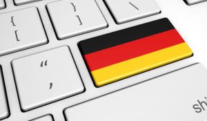 Tecla de teclado decorada con la bandera de Alemania simbolizando traduccion de guten tag al aleman cual es y como se dice.