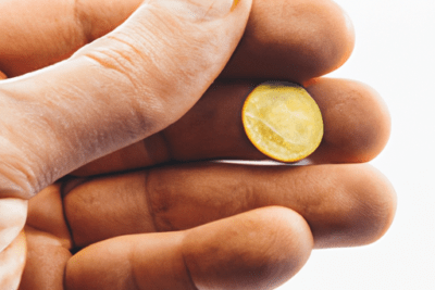 Mano sosteniendo una pequeña pastilla amarilla vive 100 caducado puede seguir siendo seguro consumirlo